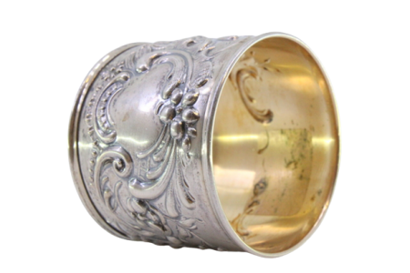 Argola de guardanapo em prata com motivos florais relevados envolvendo cartela para monograma.